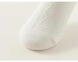 Detail of white knitted cotton baby socks with breathable hollow pattern and smooth toe seam