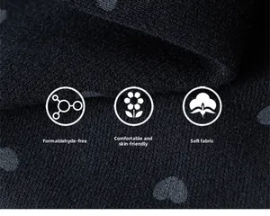 Détail macro du tricot noir doux avec motifs de cœurs gris et texture respectueuse de la peau