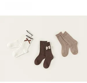 Detailed macro view of three cotton girl socks with lace trim and bowknot decorations