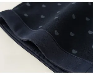 Détail du pantalon en tricot bleu marine à cœurs avec bords-côtes et coutures nettes