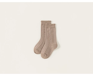 Detailed close-up of cable knit cotton socks with cute ruffle edges in soft beige