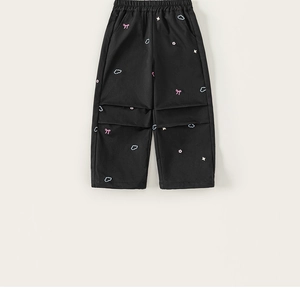 Vue détaillée du pantalon noir pour fille avec broderie de nœuds roses et fleurs