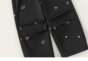 Détail du pantalon cargo noir pour fille avec broderie de nœuds et fleurs colorées