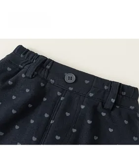 Détail du pantalon fille avec imprimé cœur, taille élastique et bouton gris soigné