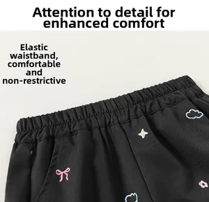 Détail de la taille élastique d'un pantalon cargo noir avec broderie nœud colorée