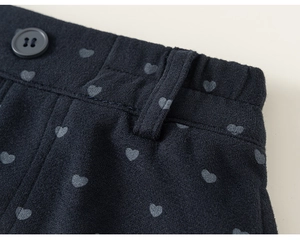 Détail du motif cœur avec bouton mat sur le pantalon décontracté bleu marine pour fille