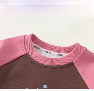 Detail shot of a child sweatshirt with pink ribbed crew neck and branded neck tape