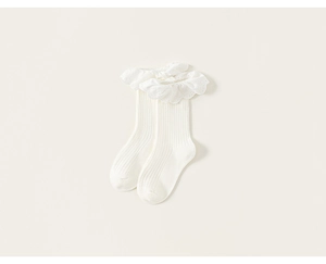 Close-up of girls' white mid-calf socks featuring elegant lace ruffle and embroidery details