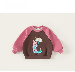 Detail of raglan sleeves and cute rabbit print on children’s brown and pink sweatshirt