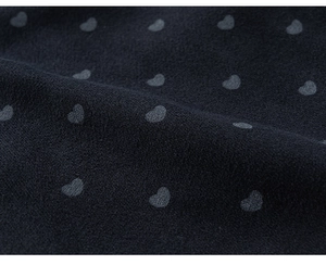 Gros plan du tissu en tricot noir avec motif délicat de cœurs gris pour enfants