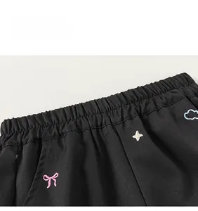 Détail du pantalon cargo noir pour fille avec taille élastique et broderie nœud colorée
