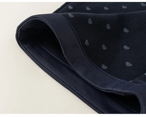 Détail du tricot bleu marine avec imprimé cœur et texture de poignet côtelé élastique
