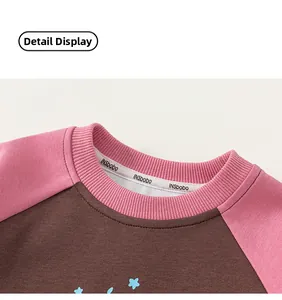 Detail of pink and brown raglan sweatshirt showing neckline ribbing and star print