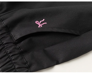 Détail du pantalon noir fille avec taille élastique et broderie de nœud rose