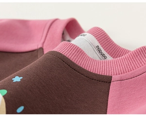 Detail of baby sweatshirt featuring soft cotton texture and pink ribbed neckline seams