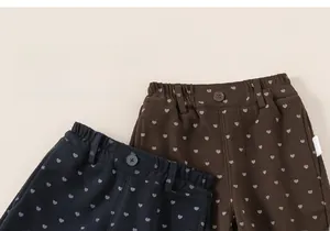 Détail de la taille élastique et boutons sur pantalon enfant à motif cœur