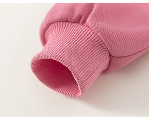 Close-up of pink ribbed cotton cuffs on a long sleeve kid sweater with tight stitching