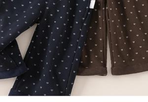 Détail de la doublure polaire épaisse et de l'imprimé cœur sur pantalon large enfant