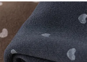Gros plan sur le tissu en maille côtelée douce avec motifs cœurs pour pantalon fille