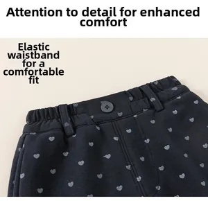 Détail de pantalon enfant avec taille élastique et motifs de cœurs gris imprimés
