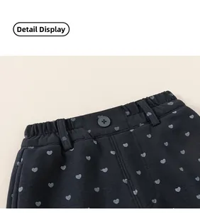 Gros plan de la taille élastique d'un pantalon enfant marine avec motifs de cœurs
