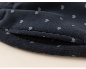 Détail du pantalon fille bleu marine à motifs cœurs montrant la texture coton et la poche