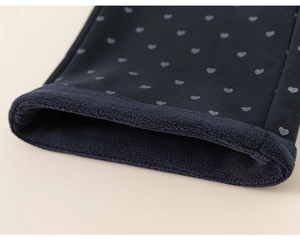 Détail de la doublure en polaire chaude et du tissu à cœurs du pantalon enfant