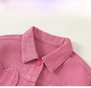 Gros plan sur la veste en velours côtelé rose pour fille avec col à revers et boutons ronds