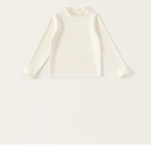 Detailed view of ruffle cuffs on kids cream long sleeve cotton ribbed knit base layer
