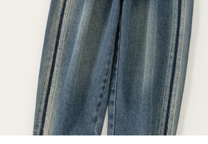 Detailed macro view of dark blue denim jeans with side stripes and retro washed texture