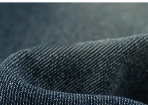 Detailed macro view of dark blue denim fabric with visible twill weave pattern
