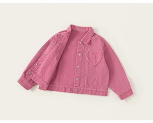 Détail d'une veste en jean rose pour fille avec poche coeur et boutons métalliques