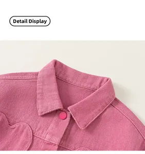 Détail du col en velours côtelé rose avec bouton et broderie cœur sur la veste fille