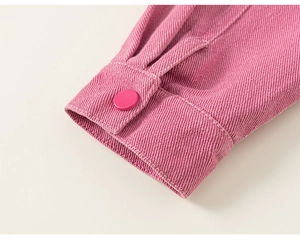 Détail du poignet de la veste en jean rose avec texture sergé et bouton rond mat