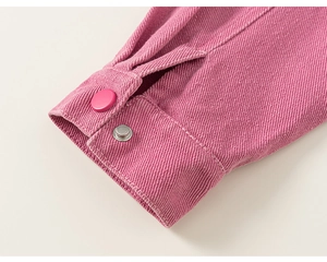 Détail du poignet d'une manche violet rose avec boutons assortis et texture de tissu