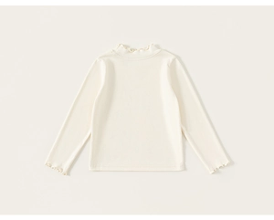 Detail of soft cream cotton long sleeve undershirt with elegant ruffled collar and cuffs