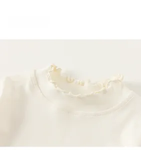 Close-up of cream-colored ribbed knit fabric showing ruffled collar details for kids