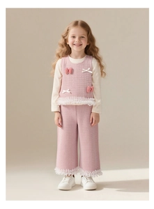Détail d'un ensemble en tweed rose pour filles avec ourlet en dentelle et nœud rouge