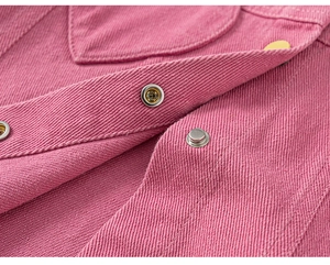 Détail de la veste en velours rose avec boutons-pression argentés et doubles coutures