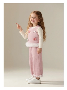 Vue détaillée du gilet et du pantalon en tricot rose avec dentelle et nœuds blancs