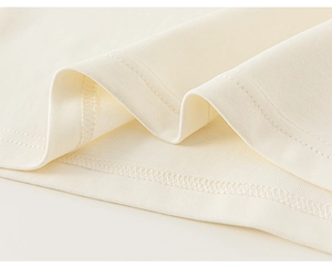 Detailed close-up showing precision double-needle hem stitching on girls knit cotton shirt