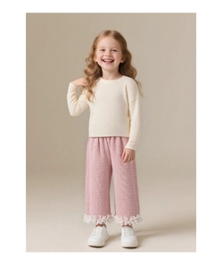 Détail du pantalon large en tweed rose avec appliqués de fleurs 3D et pull en tricot