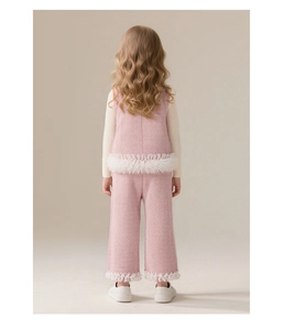 Détail d'un ensemble gilet en tweed rose et pantalon large avec bordures à franges