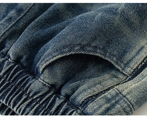 Detail of blue denim fabric with washed effect, twill weave, and elastic pleated pocket