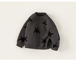 Detail of grey knitted sweater for boys featuring a large black star jacquard pattern