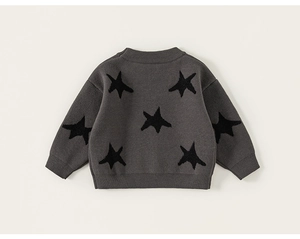 Detail of grey knitted boy sweater featuring black star jacquard and ribbed cuffs