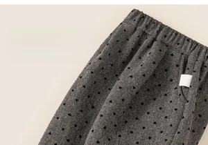 Detail of grey children's trousers with black heart polka dots and elastic waistband