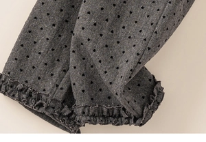 Close-up of grey fabric with black heart patterns and decorative ruffled edge detail