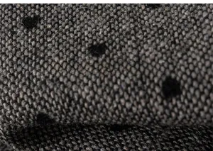 Macro detail of thick grey winter fabric featuring black polka dots for children's trousers