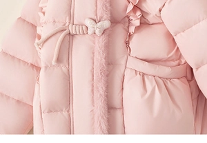 Détail de veste d'hiver rose avec broderie papillon et bordure en fausse fourrure